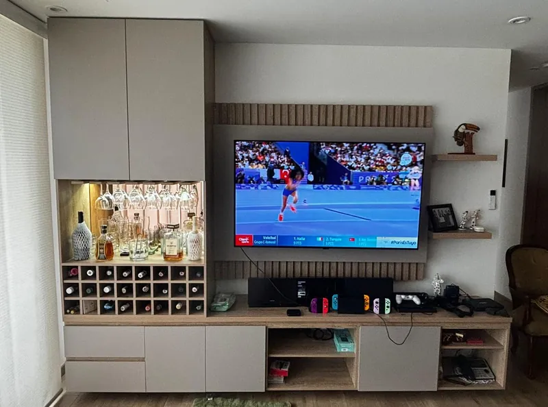 Mueble de TV con panel de listones de madera, minibar con copero y botellero, en laca topo y madera