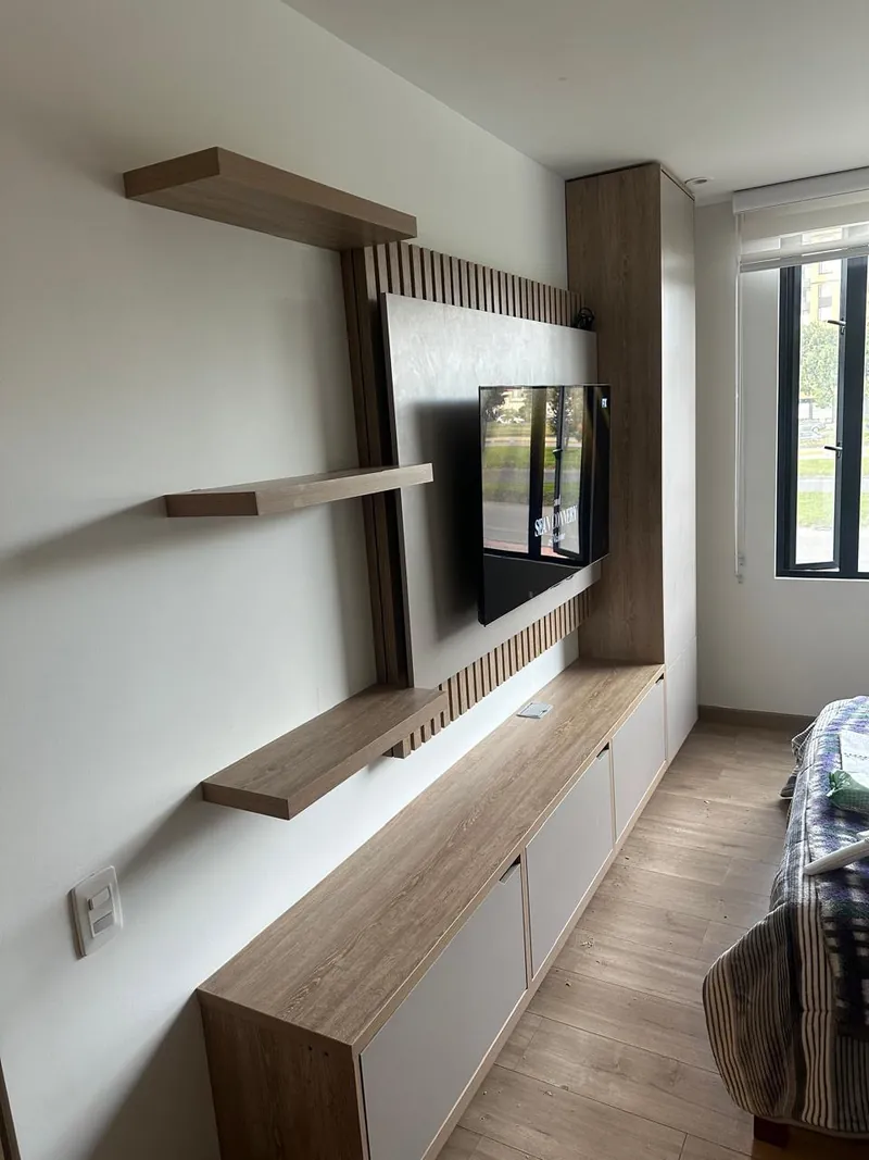 Pared de TV con panel de listones, repisas flotantes de madera y mueble bajo
