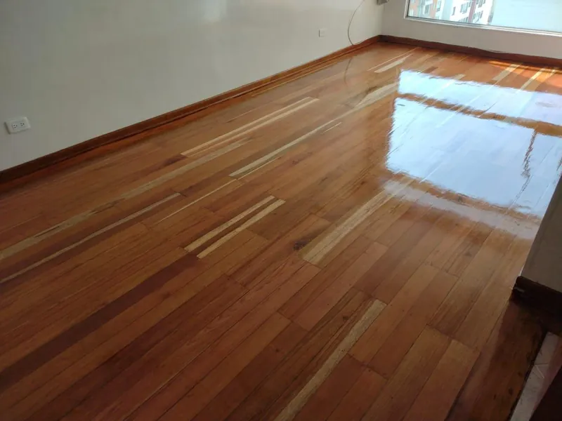 Piso de madera maciza pulido con acabado brillante en una sala