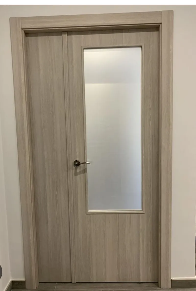 Puerta en chapa gris roble con visor vertical de vidrio esmerilado